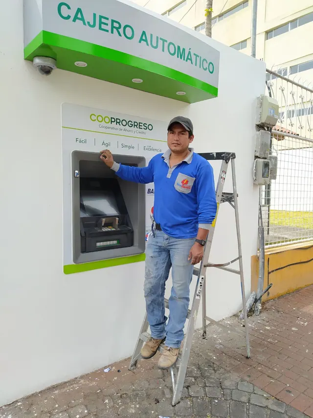 Integrante de SeviElectro durante una intervención junto a un cajero automático
