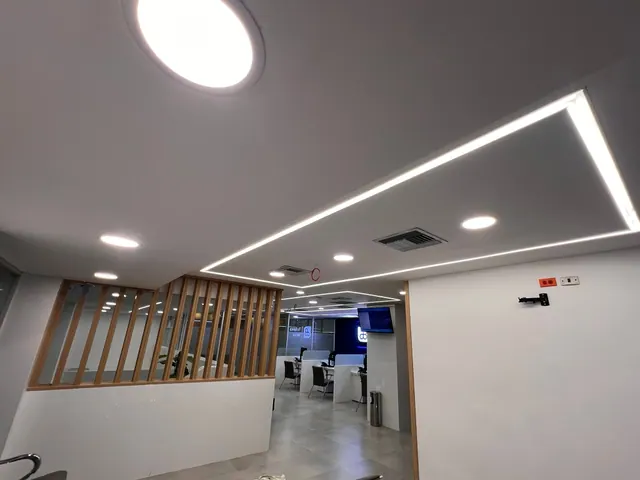 Interior comercial con iluminación LED y techo de líneas geométricas