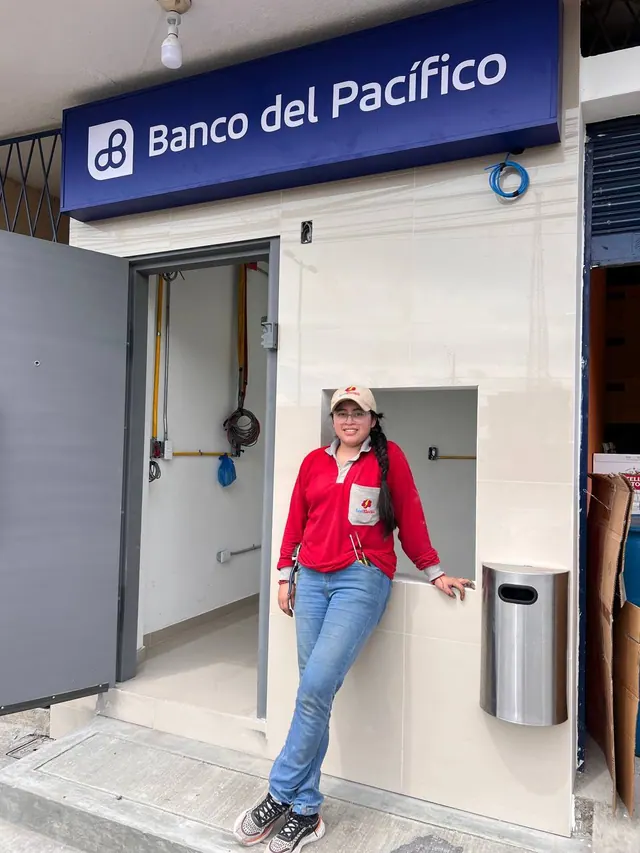 Integrante de SeviElectro junto al acceso de Banco del Pacífico, con canalizaciones y cableado a la vista